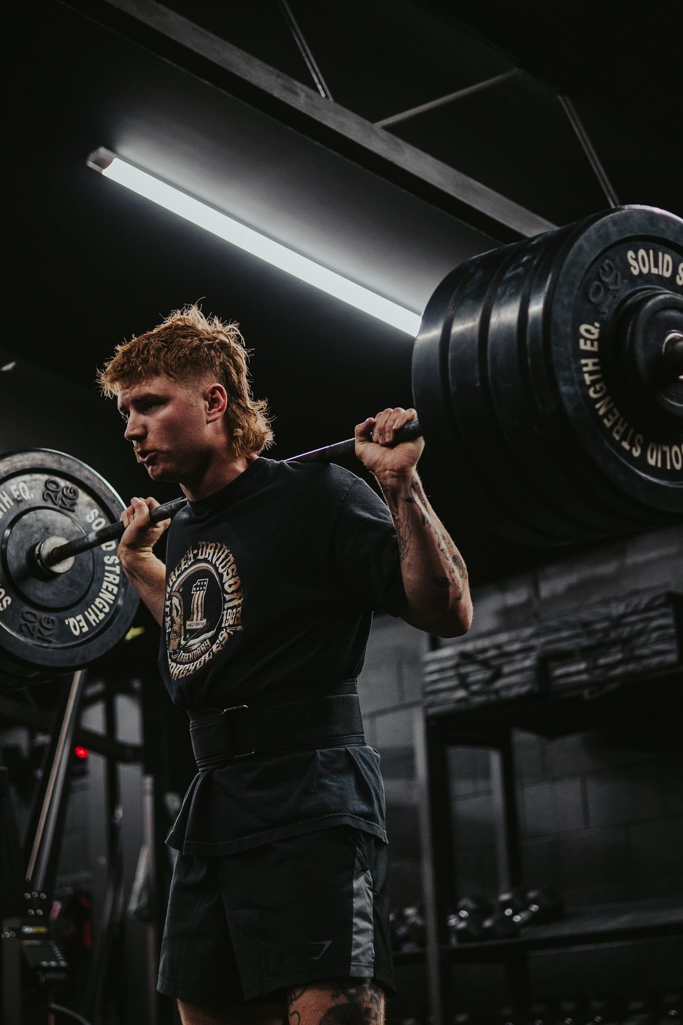 Athlete under a heavily loaded barbell during a Hybrid Theory strength session