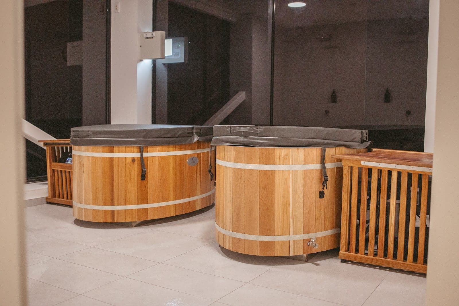 Two cedar cold-plunge barrels in the communal ice bath room