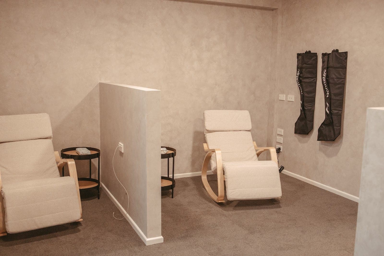 NormaTec compression boots beside recliner chairs in the recovery lounge