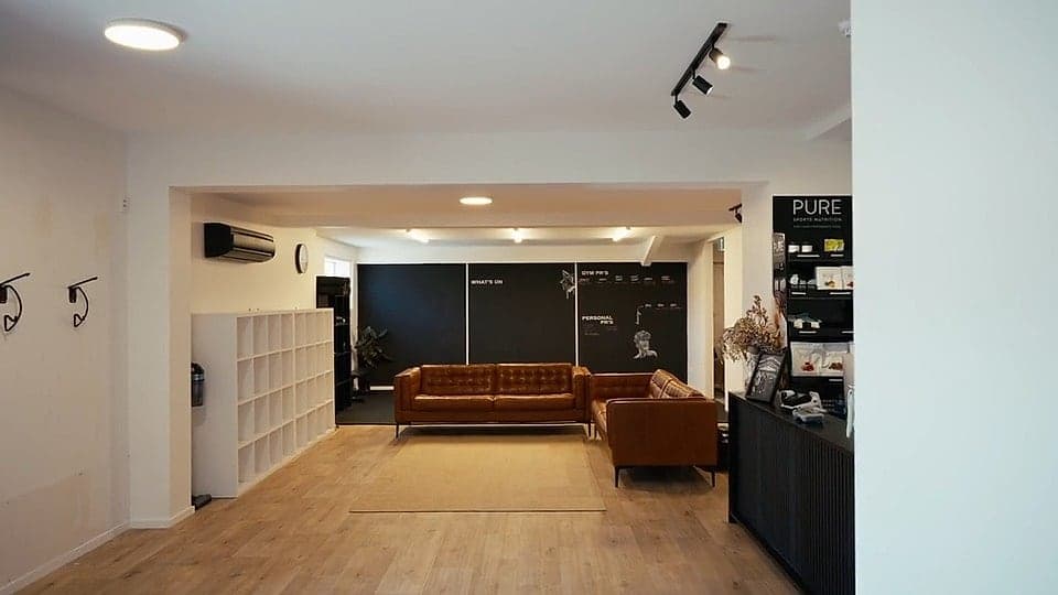 The Hybrid Theory reception lounge with leather couches, the members' PB wall and the front desk