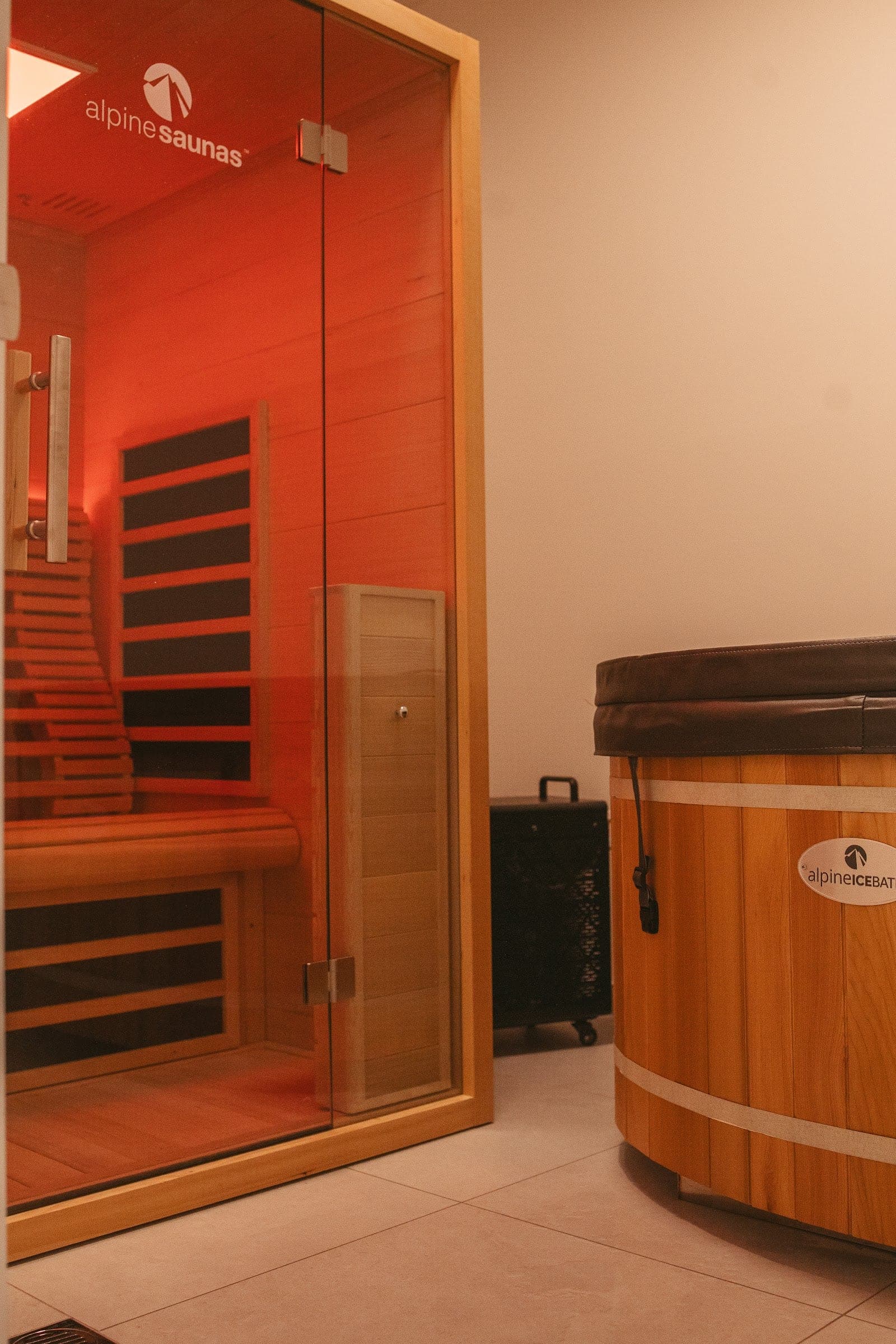 A private recovery suite with an infrared sauna beside a cedar ice bath