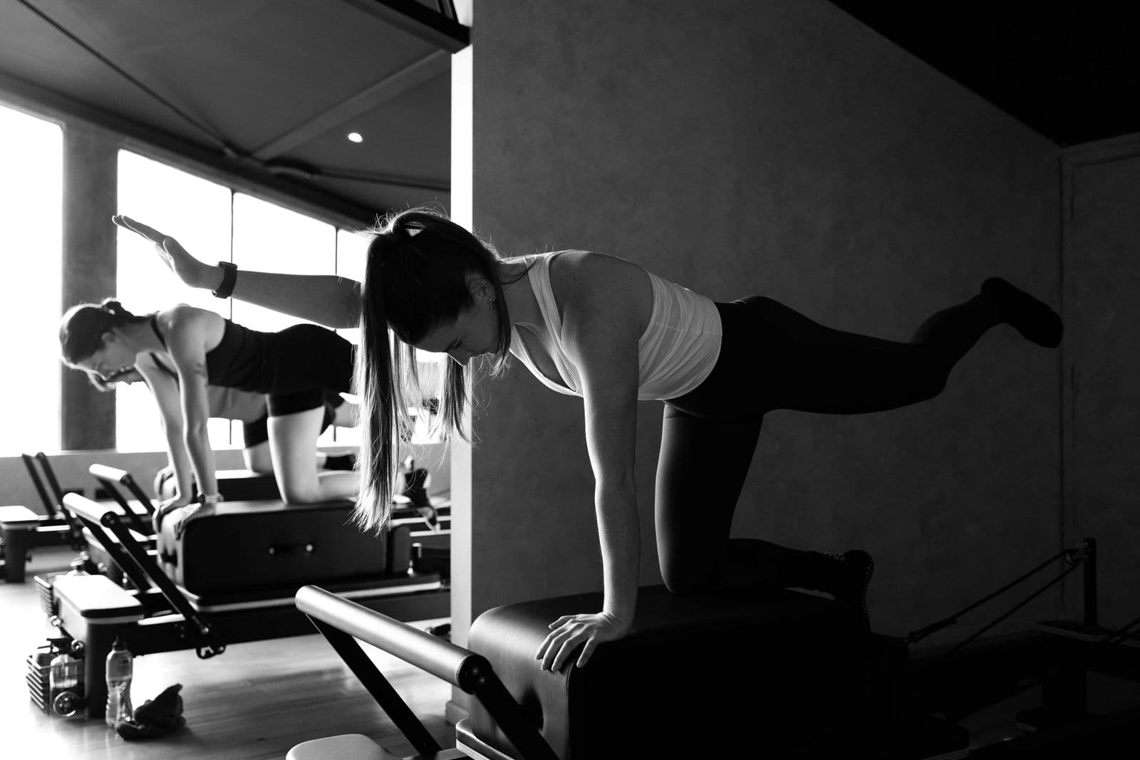 Two members training side by side on reformers in the Hybrid Theory studio