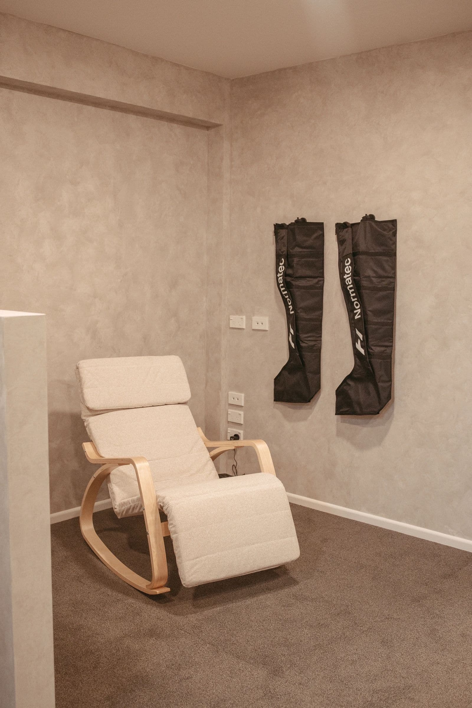 Members relaxing in Normatec compression boots in the recovery lounge